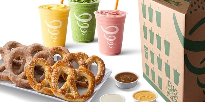 Jamba smoothies in yellow, green, and pink, with pretzels and dipping sauces, next to a branded box.